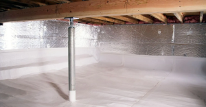 A basement or crawl space shows a concrete floor with a support column and exposed wooden ceiling joists, with reflective insulation material visible on the walls.